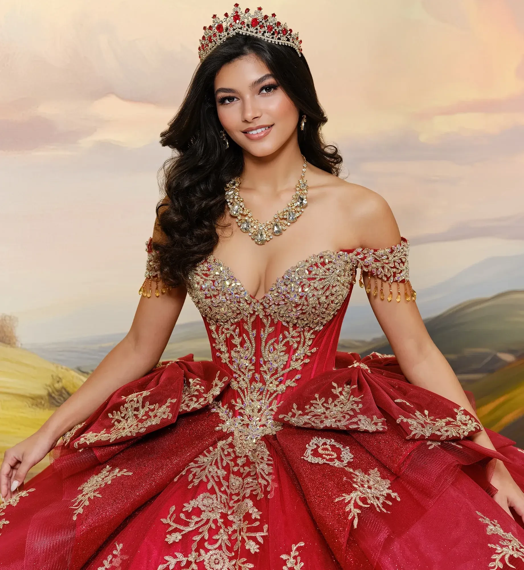A young woman in an elaborate red gown with gold embellishments and a tiara, smiling and posing against a scenic background.