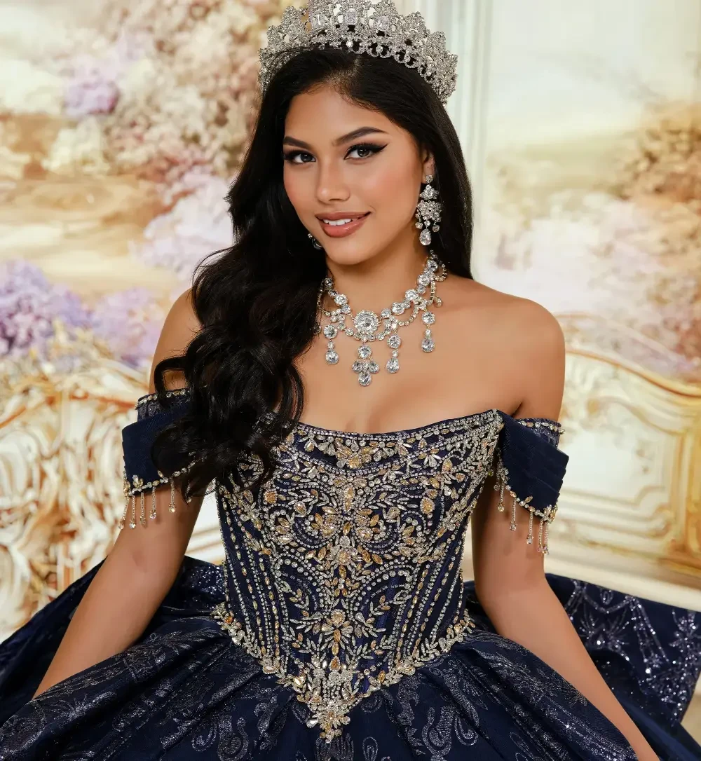 A young woman wearing a lavish dark blue gown with intricate silver embroidery, standing gracefully in an ornate room with elegant decor.