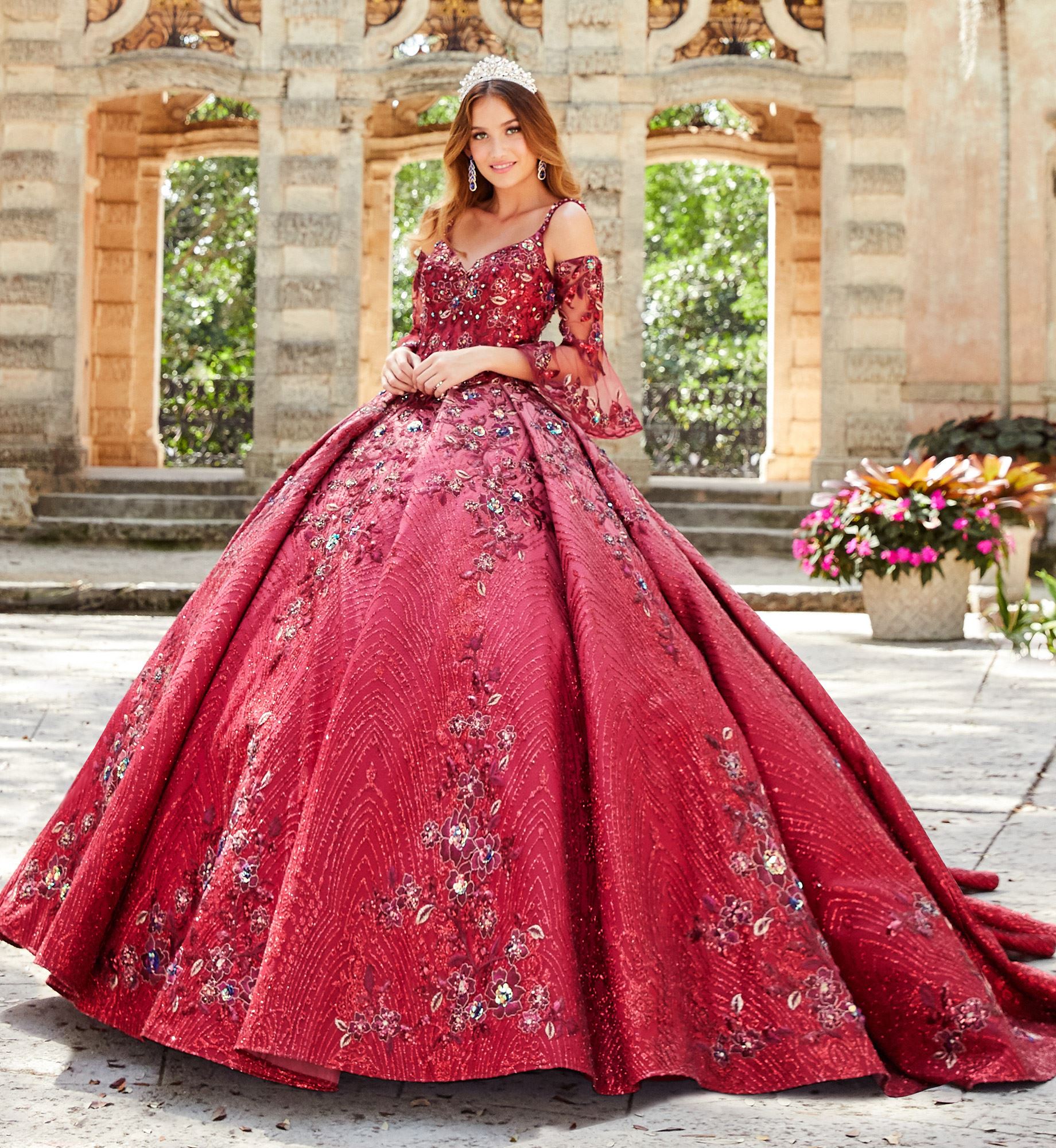 Brunette model in ruby red quinceañera dress with long sleeves