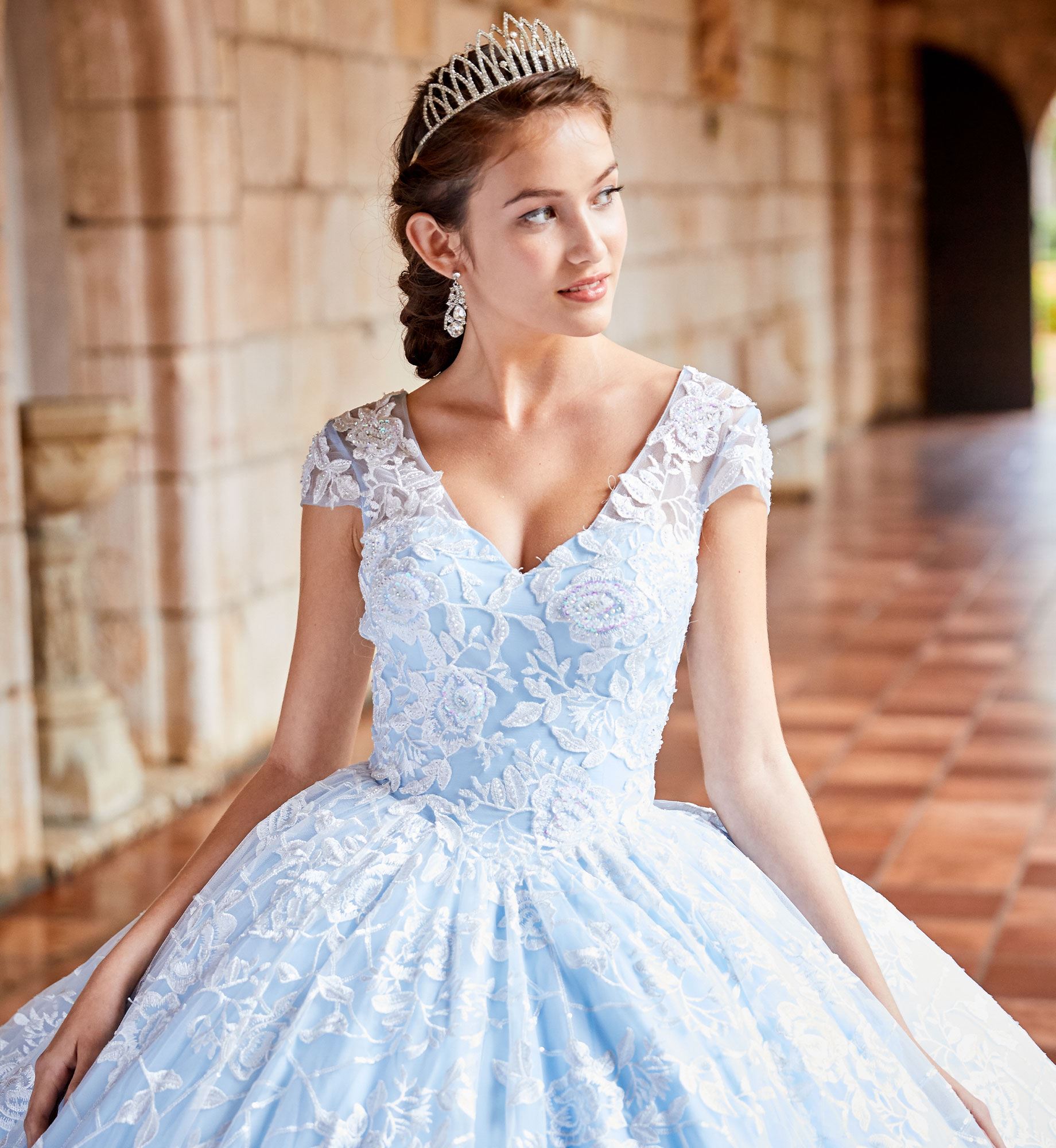 Brunette model in short sleeve blue quinceañera dress