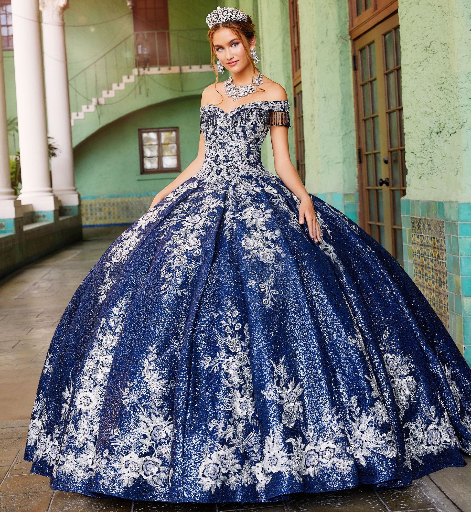 Brunette model in off the shoulder blue and silver quinceañera dress